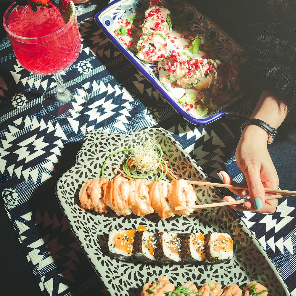 Mesa con sushi y cóctel en Ozumo